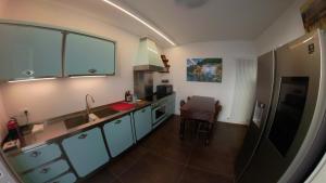 uma cozinha com armários azuis e uma bancada em La Casa nel Parco Lecco em Lecco