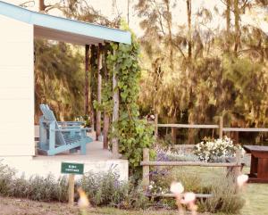 een tuin met een blauwe stoel op een veranda bij Cheverells Farm in Grabouw