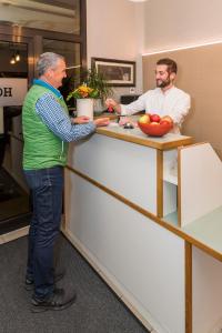 dos hombres parados en un mostrador en una cocina en Hotel Hiltruper Hof en Münster