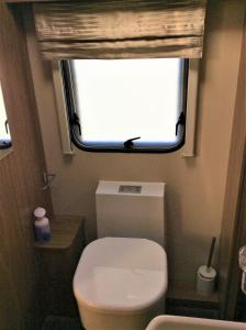 a small bathroom with a toilet and a window at Le Boterff Gites et Camping in Saint-Mayeux