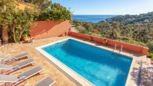 - une piscine avec des chaises et une vue sur l'océan dans l'établissement Villa Coral, à Tamariu