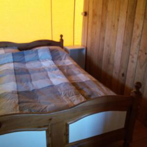 ein Bett mit einem Holzrahmen in einem Zimmer in der Unterkunft Safaritent de Berghoeve in Ruinen