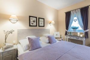 a bedroom with a bed with purple sheets and a window at Villa Aurora in Bojanowo