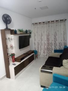 un salon avec une télévision et un canapé dans l'établissement Studio unita143, à Praia Grande 17 autres photos