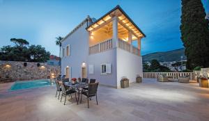 a patio with a table and chairs in front of a house at Villa Enigma in Dubrovnik