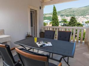 a table and chairs on a balcony with a view at Villa Enigma in Dubrovnik