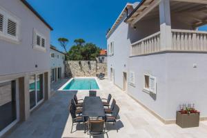 a patio with a table and chairs and a swimming pool at Villa Enigma in Dubrovnik