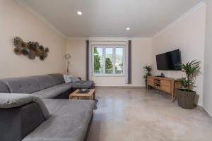 a living room with a couch and a flat screen tv at Villa Enigma in Dubrovnik