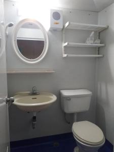 La salle de bains est pourvue d'un lavabo, de toilettes et d'un miroir. dans l'établissement Old street little house, à Chaozhou