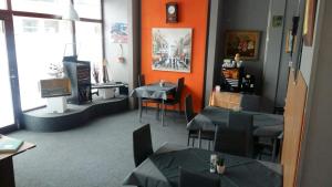 a restaurant with tables and chairs and orange walls at Pension am Piko-Platz in Sonneberg