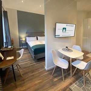 a hotel room with a bed and a table and chairs at Nurban Apartments Oldtown in Nuremberg