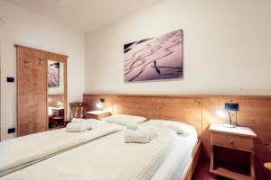 - une chambre avec 2 lits et une photo sur le mur dans l'établissement Appartamenti Residence La Roggia, à Pozza di Fassa