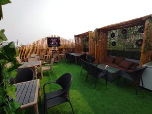a patio with a couch and tables and chairs at The Avenue Hotel Ballygunge in Kolkata