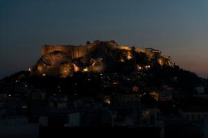 a castle on top of a mountain at night at Hotel Adonis in Athens