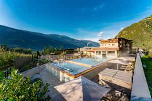 ein Haus mit einem Pool und einem Berg in der Unterkunft Vitalpina Hotel Waldhof in Rabland