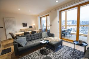 a living room with a couch and a table at Apartment No25 Residence Javor in Železná Ruda