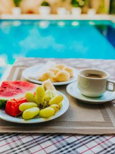 una mesa con dos platos de comida y una taza de café en Hotel Antiga Roma en Belém