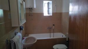 La salle de bains est pourvue d'une baignoire, d'un lavabo et de toilettes. dans l'établissement Apartments Jere, à Primošten