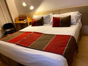 a bedroom with a large bed with red and brown pillows at Recoleta Apartment in Buenos Aires