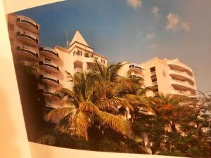 uma imagem de um edifício com palmeiras em frente em Appartement 1 chambre Sapphire Beach em Cupecoy