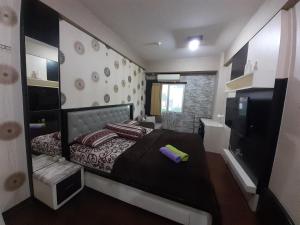 a bedroom with a large bed and a bathroom at Apartemen SUKARNO HATTA Elwarda Ely in Malang