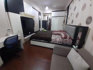 una camera con letto, divano e TV di Apartemen SUKARNO HATTA Elwarda Ely a Malang