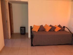 a bedroom with a bed with orange and brown pillows at Cabañas Buen Aike in Malargüe