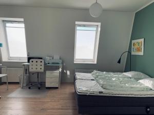 una camera con letto e scrivania e due finestre di ApartmentInCopenhagen Apartment 93 a Copenaghen