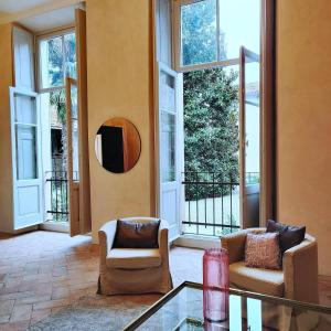 Villa Guardia的住宿－Dandelion Como Suites & Park，客厅配有两把椅子和一张玻璃桌