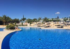 a large swimming pool next to a beach with umbrellas at Camping Tucan - Mobile Homes by Lifestyle Holidays in Lloret de Mar