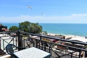 a beach area with chairs, tables and umbrellas at Sea View Rental Front Beach in Golden Sands