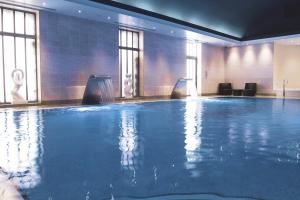 a large swimming pool in a hotel room at Fistral Beach Hotel and Spa - Adults Only in Newquay