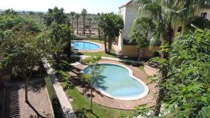 una vista aérea de dos piscinas en un patio en HL 006 Luxury 2 bedroom apartment on HDA Golf Resort, Murcia, en Fuente Alamo