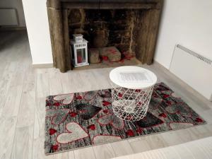 a rug on the floor with a table and a fireplace at La casa nel Borgo Sospeso "con vasca "no idro " e vista panoramica" in Vitorchiano