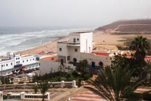 a view of a beach and a white building at Ifni Surf Hostal in Sidi Ifni
