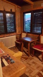 Zimmer mit einem Tisch, Stühlen und Fenstern in der Unterkunft Belette Apartments & Park in Nikšić