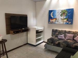a living room with a couch and a flat screen tv at Residencial Christal Das Flores in Florianópolis