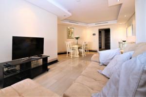 a living room with a couch and a flat screen tv at Estepona East Apartment MIA in Estepona