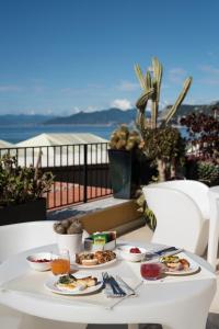 a white table with plates of food on a balcony at Hotel Albatros Varigotti in Varigotti