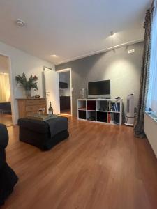 a living room with a couch and a flat screen tv at Appartement de Gouw in Noordgouwe