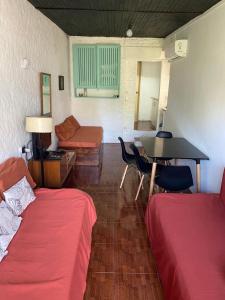 Cette chambre comprend deux lits, une table et un canapé. dans l'établissement Rincón de Araus, à Colonia del Sacramento