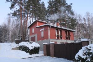 a house with smoke coming out of it in the snow at Külalismaja Malaika in Põlva