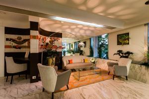 a living room with a couch and chairs at Hôtel Hélios in Juan-les-Pins