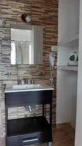 a bathroom with a sink and a mirror at Hotel Brisas Marinas in San Clemente del Tuyú