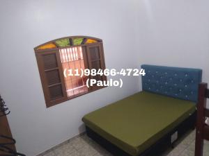 Zimmer mit einer Bank und einem Fenster in der Unterkunft Casa inteira para temporada - Mongaguá in Mongaguá