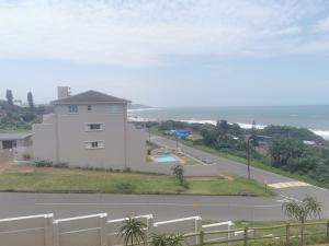 a white house on the side of a road at Seahorse unit 4 in Scottburgh