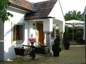 ein weißes Haus mit einem Tisch und Stühlen davor in der Unterkunft Romantikchalet in Breitenbrunn