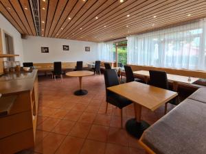a restaurant with tables and chairs in a room at Hotel am Hachinger Bach by Blattl in Neubiberg