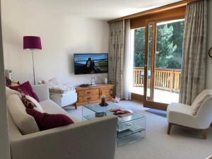 uma sala de estar com um sofá e uma televisão em Abitaziun Silvia Sur Baselgia em Cunter