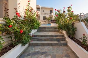un conjunto de escaleras con rosas rojas. en Villa Krini, en Kalathas